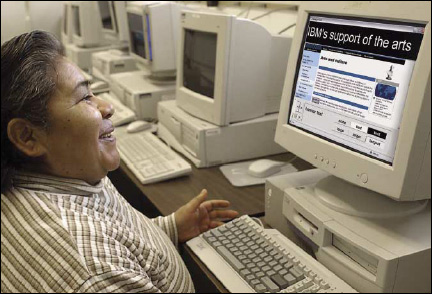 lady in a computer lab looking at a web page with a  high contrast banner of enlarged text at the top of the page